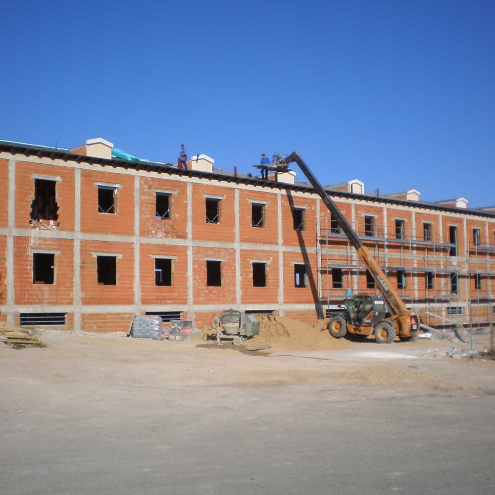 Obra de edificación en Ciudad Real con maquinaria, andamios y varios gremios coordinados